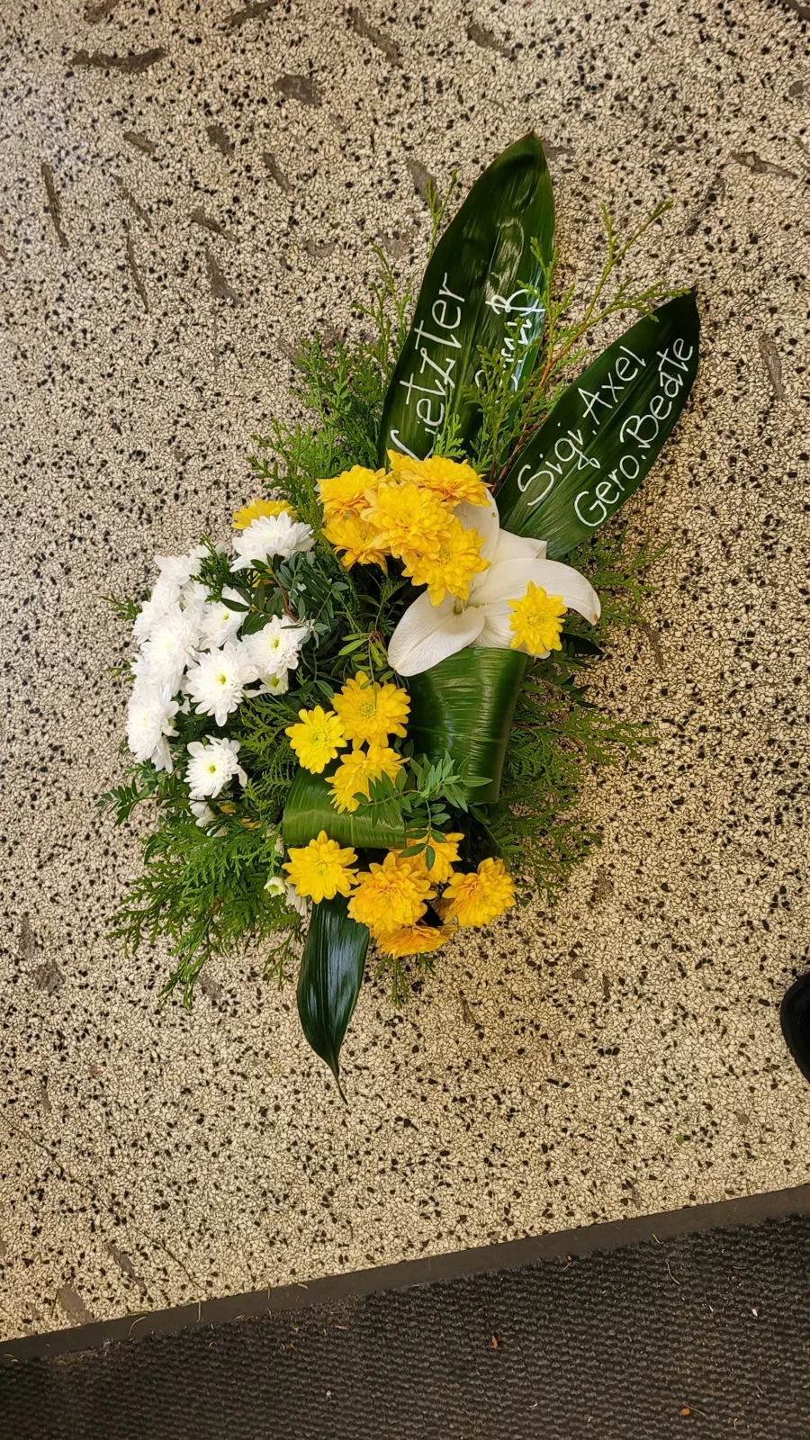 Weißer Trauergruß mit Rosen und Gerbera und Schleife. Pusteblume Halle